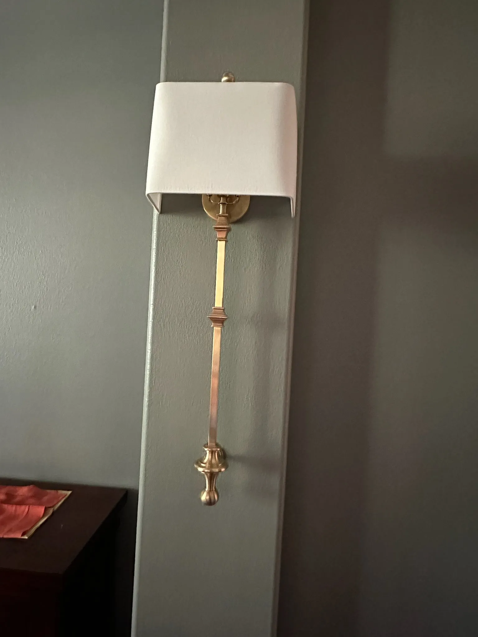 Elegant contemporary bath sconce featuring a brushed brass frame and unique clear plaid glass cylinder. Perfect for illuminating modern or transitional bathroom spaces.